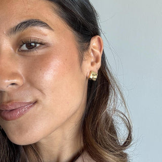 Woman wearing elegant gold chunky hoop earring, close-up jewelry fashion shot