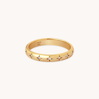 Gold band ring with star-shaped diamond accents on white background, elegant jewelry.