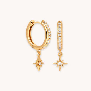 Gold hoop earrings with crystal star charms and pavé cubic zirconia accents on white background